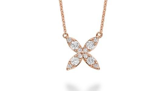 A rose gold, four-petaled flower pendant necklace with pave set diamonds