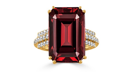 An emerald cut garnet ring with a yellow gold setting and diamond accent stones