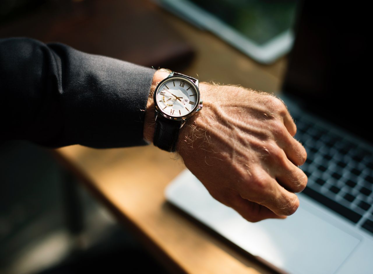 A close-up of a man checking the luxury watch on his wrist.