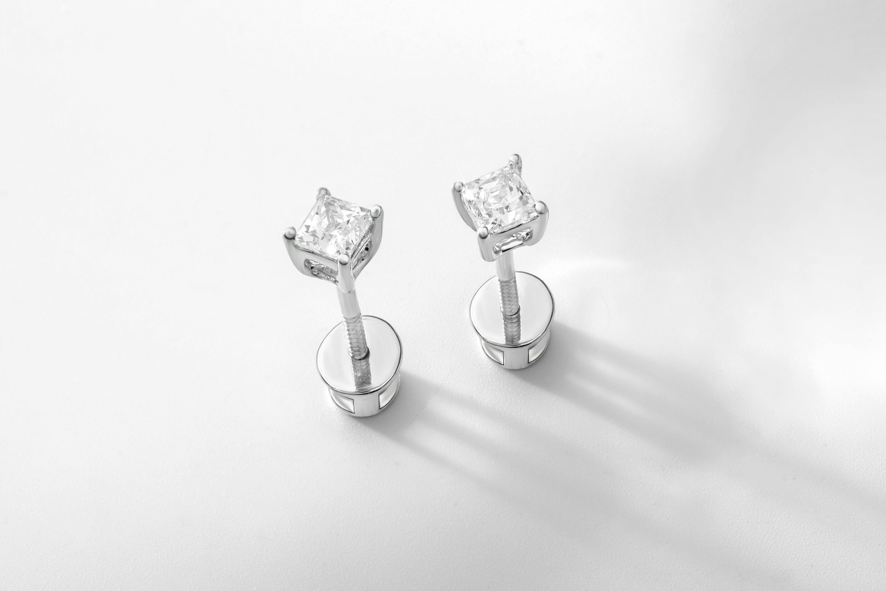 A close-up of a pair of simple yet elegant diamond stud earrings.