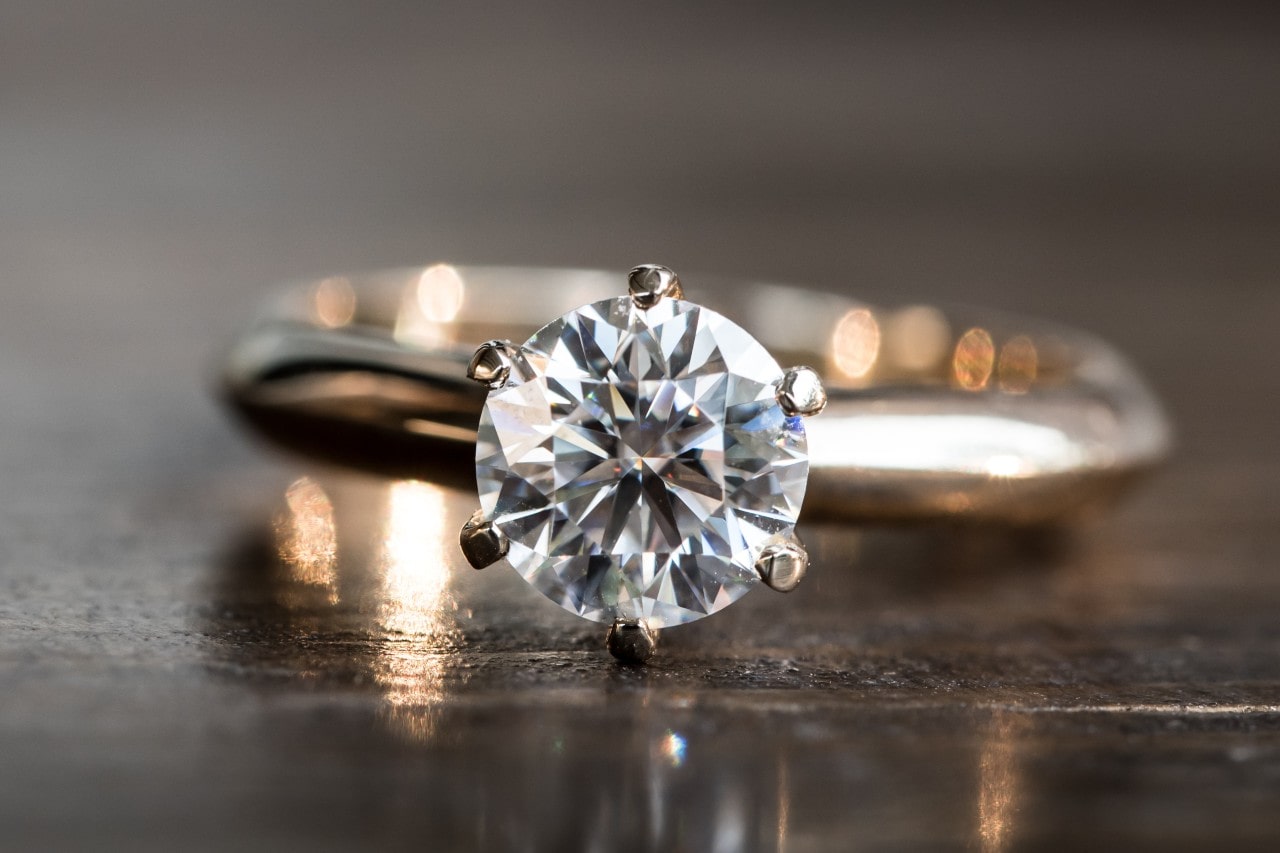 a round cut engagement ring resting on a table