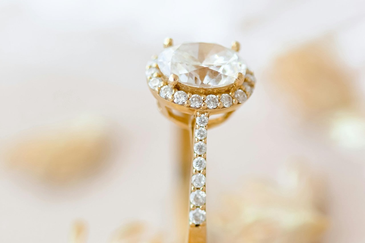 a gold engagement ring with a round-cut center stone and side stones