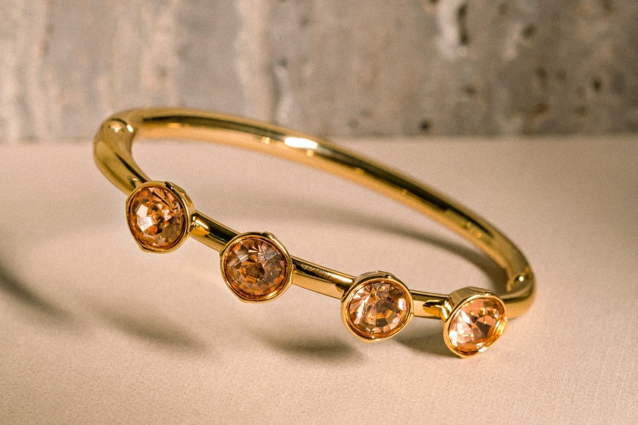 A close-up of an elegant gold ring with 4 small topaz stones.