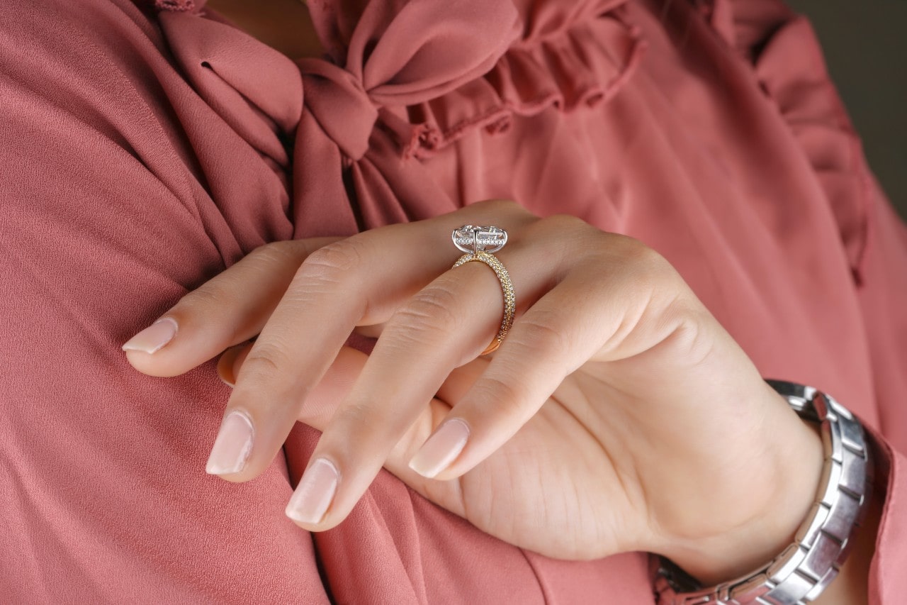 Side view of a hidden halo engagement ring with micropave along the band